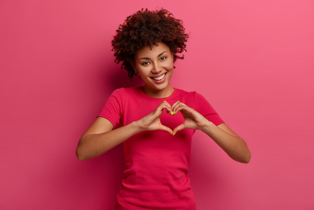 a woman making a heart shape with her hands